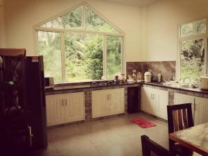 a kitchen with white cabinets and a large window at Baan Blue River 2 bedrooms in Ban Nai Sa