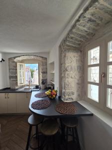 a kitchen with a table with fruits on it at Bel Composto Apartments in Perast