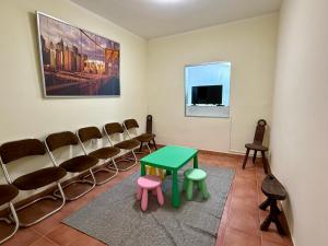 a waiting room with a green table and chairs at Casa Generoso en Navalcán in Navalcán