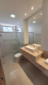 a bathroom with a sink and a toilet and a mirror at Cantinho do Caribe Paraibano in João Pessoa