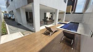 a balcony of a building with chairs and a pool at Cantinho do Caribe Paraibano in João Pessoa