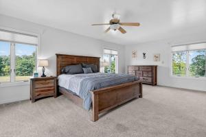 Un dormitorio con una cama y un ventilador de techo. en Grass Lake Retreat with Game Room & Fire Pit, en Grass Lake
