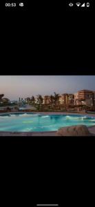 ein Fernsehbildschirm mit einem Bild eines Swimmingpools in der Unterkunft قريه روزانا في الساحل الشمالي الاسكندريه كيلو 55 in Dawwār al Ḩajj Aḩmad