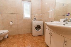 Un baño con lavadora y lavabo. en Apartments Star 3, en Pag 38 fotos más