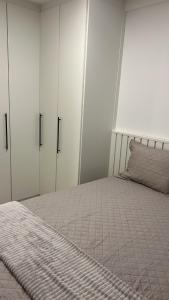 a bedroom with white cabinets and a large bed at Conforto e estilo Praia do Forte in Cabo Frio