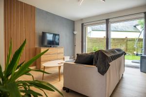 a living room with a couch and a tv at Maison à 2 pas des plages in Roscoff
