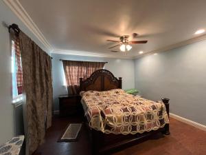 a bedroom with a bed and a ceiling fan at Historic Farmhouse on Hogan Ave in Reedley