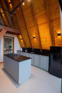 a large kitchen with wooden ceilings and a counter top at Chalé Encanto de Maria em Teresópolis in Teresópolis