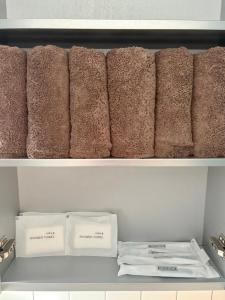 a row of brown towels sitting on a shelf at Aralla Stay-고척돔 15분 거리 #홍대 이태원 영등포 여의도 대중교통 30분 내 도착 #목동역 도보 15분 #목동역 차로 5분 in Seoul