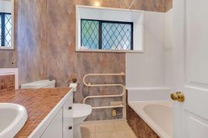 a bathroom with a sink and a tub and a toilet at Iles House Rotorua in Rotorua +17 photos