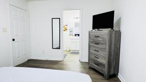 a bedroom with a television on top of a dresser at Cozy Escape, rooms in Charlotte in Charlotte