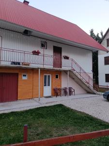 a white building with a red roof and a table at Apartments Nemanja in Žabljak