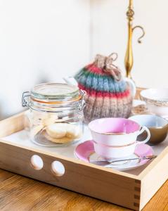 a wooden tray with a cup and a jar on a table at The Wellington Arms in Baughurst
