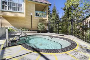 a hot tub in a backyard with a fence at The Snowbird by Whiski Jack in Whistler