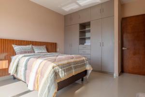 una camera da letto con un letto con testiera in legno di lujoso apto,en el corazón de Cancún Torre Tzalam a 5 min de la entrada a la zona hotelera a Cancún Altre 21 foto