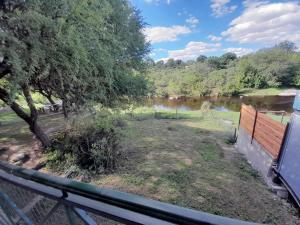 une vue d'une rivière depuis une clôture dans l'établissement CASA EL GRINGO ubicada en Villa Parque Siquiman con vista al río tres habitaciones y capacidad para ocho personas, à Villa Parque Siquiman