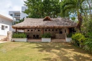 una casa con tetto di paglia e cortile di lujoso apto,en el corazón de Cancún Torre Tzalam a 5 min de la entrada a la zona hotelera a Cancún