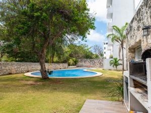 una piscina in un cortile con un albero di lujoso apto,en el corazón de Cancún Torre Tzalam a 5 min de la entrada a la zona hotelera a Cancún
