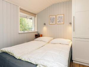 una cama en una habitación con ventana en 6 person holiday home in Ålbæk, en Ålbæk