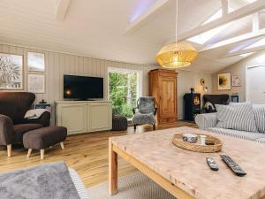 Una sala de estar con una mesa y un televisor. en 6 person holiday home in Ålbæk, en Ålbæk