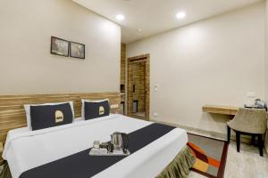 a hotel room with a bed and a desk at Super Townhouse OAK Shubhham Regency in Kolkata