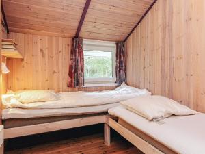 2 Betten in einem Holzzimmer mit Fenster in der Unterkunft Luxurious Retreat by Bratten Strand-By Traum in Jerup