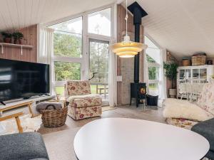 ein Wohnzimmer mit Fernseher und Tisch in der Unterkunft Luxurious Retreat by Bratten Strand-By Traum in Jerup