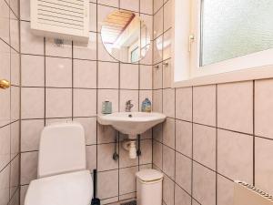 ein Badezimmer mit Toilette, Waschbecken und Spiegel in der Unterkunft Luxurious Retreat by Bratten Strand-By Traum in Jerup + 32 Fotos