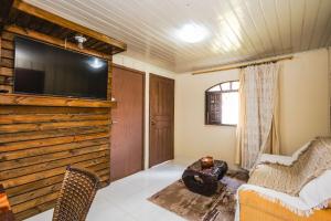 a living room with a flat screen tv on a wall at Chácara Santa Rita - Campo Magro | Gonzaga Stays in Campo Magro