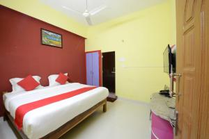 ein Schlafzimmer mit einem Bett mit einer roten Wand in der Unterkunft Hotel O Vellore New Bus Station Formerly SP Highway Inn in Vellore