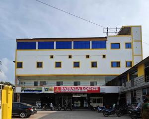 a white building with blue windows on a street at Super Hotel O Vellore New Bus Station Formerly SP Highway Inn in Vellore