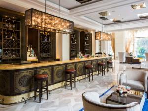 a bar at a hotel with bar stools at Hotel Des Arts Saigon Mgallery Collection in Ho Chi Minh City