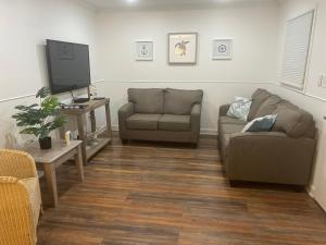 a living room with two couches and a flat screen tv at Vacation Bliss LLC in Hilton Head Island