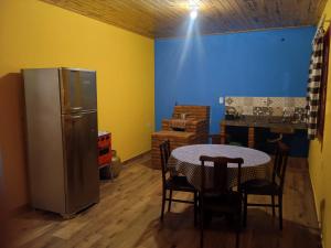a kitchen with a table and a refrigerator at Chalé Arminda Costa in Ouro Preto