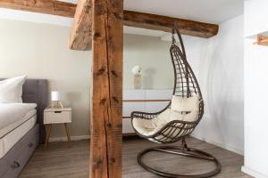 a hanging chair in a bedroom next to a bed at Ferienwohnung am Stadtschloss in Quedlinburg