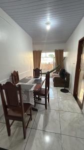 a dining room with a table and chairs and a couch at Pousada Ribeiro 2 in Belém