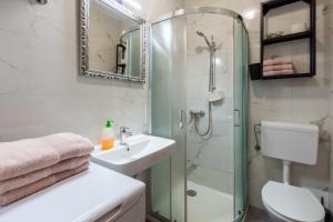 a white bathroom with a shower and a sink at Apartments with parking space Basanija, Umag - 21418 in Bašanija +13 photos