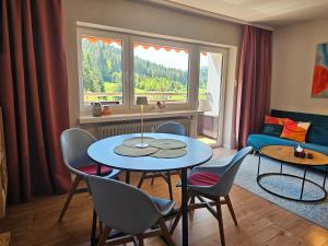 a living room with a table and chairs and a couch at Ferienwohnung Vogelnest mit weitem Blick über den Schwarzwald in Baiersbronn +22 photos