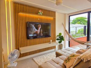 salon z płaskim telewizorem na ścianie w obiekcie Aptos luxo Praia de Carneiros - Edf Mar de Campas - 50m do mar By BLU stay w mieście Tamandaré
