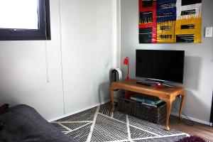 a living room with a tv on a table at Night Sky Magic in Olive Grove in Gladstone