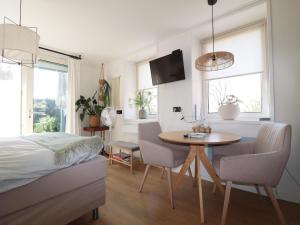 a bedroom with a bed and a table and chairs at Beautifully styled apartment in Engelum