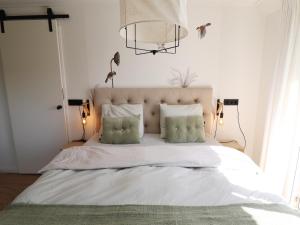 a bedroom with a large white bed with a chandelier at Beautifully styled apartment in Engelum