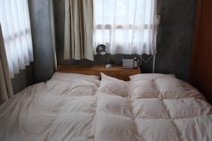 1 cama no hecha en un dormitorio con ventana en めくる, en Matsumoto 3 fotos más
