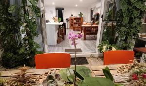 a dining room with orange chairs and a table with a plant at Executive King Suite - Ensuite in Holmview