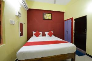 Un dormitorio con una cama grande con paredes rojas. en Super Hotel O Vellore New Bus Station Formerly SP Highway Inn, en Vellore
