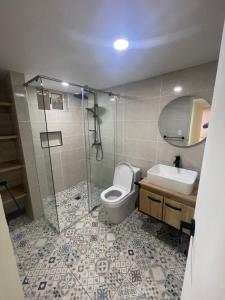 a bathroom with a toilet and a sink and a shower at Comfortable apartment in Pereira