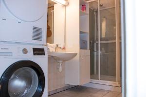 a bathroom with a washing machine and a sink at Arctic Apartment Heart of Tromsø in Tromsø +72 photos