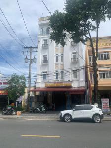 a white car parked in front of a white building at Nhà nghỉ TÂN MINH THOẠI in Phu Quoc