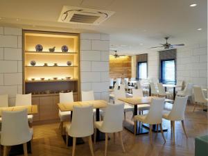 横浜市にあるFar East Village Hotel Yokohama - Vacation STAY 35285vのテーブルと白い椅子のあるダイニングルーム