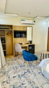 a bedroom with a blue chair and a desk at شقق اليمامة المميز الفندقية ينبع in Yanbu
